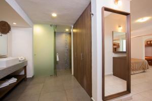 a bathroom with a shower and a sink and a mirror at Crown Paradise Club All Inclusive in Puerto Vallarta