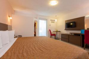 a hotel room with a large bed and a desk at Crown Paradise Club All Inclusive in Puerto Vallarta