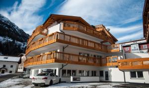 a building with wooden balconies and a car parked in front at Top View - Panorama Apart Sölden in Sölden
