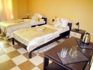 2 Betten in einem Zimmer mit 2 Tischen in der Unterkunft Перлина in Morschyn