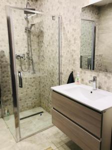 een badkamer met een wastafel en een douche bij Mira apartman in Debrecen
