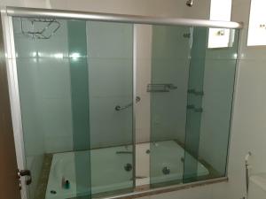 um chuveiro com uma porta de vidro na casa de banho em Hotel Dom Otto em Vespasiano