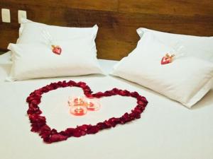 two hearts are on a bed with two pillows at Hotel Dom Otto in Vespasiano