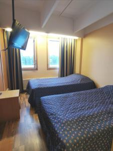 pokój hotelowy z 2 łóżkami i telewizorem z płaskim ekranem w obiekcie Hotelli Iisoppi w mieście Nokia