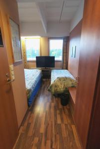 Pokój z 2 łóżkami, biurkiem i 2 oknami w obiekcie Hotelli Iisoppi w mieście Nokia