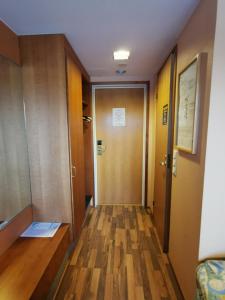 a room with a wooden floor and a wooden door at Hotelli Iisoppi in Nokia