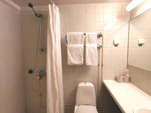 uma casa de banho com um chuveiro, um WC e um lavatório. em Hotelli Iisoppi em Nokia