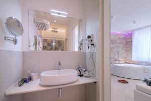 a bathroom with a sink and a tub and a mirror at Amalfi Suite Boutique Hotel in Amalfi