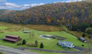 an aerial view of a house and a lake in a field at The Maples - Hot tub! Amazing views, pets welcomed in Ellicottville