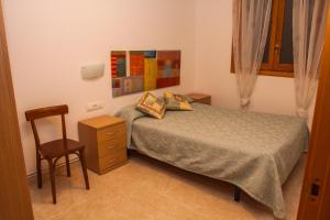 una piccola camera da letto con un letto e una sedia di Apartments Ca la Victoria a La Vilella Baixa Altre 49 foto