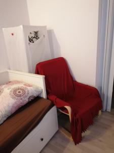a bedroom with a bed and a red blanket on a chair at Jasmin in Laichingen