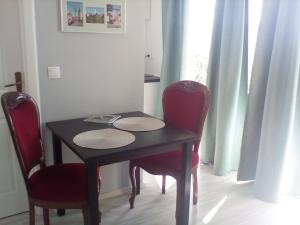 a table with two red chairs and a black table and a table at Ana Rooms in Krk