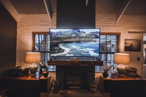 ein Wohnzimmer mit einem Flachbild-TV und einem Kamin in der Unterkunft 3 on Pine, Luxury Home[WiFi,DSTV,Parking incl] in George