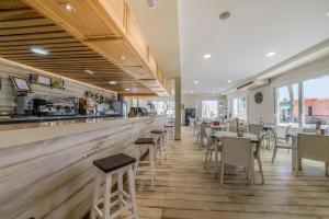 un restaurante con bar, mesas y sillas en Glamping -Bungalows El Faro, en Conil de la Frontera