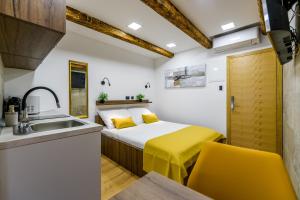 um quarto com uma cama e uma cozinha com um lavatório em Urban Apartments with sauna em Zadar