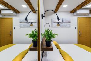 um quarto com duas camas e dois vasos de plantas em Urban Apartments with sauna em Zadar