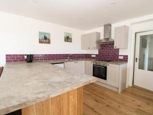 une cuisine avec des armoires blanches et un comptoir en marbre dans l'établissement Waveney View Cottage, à Great Yarmouth 12 autres photos