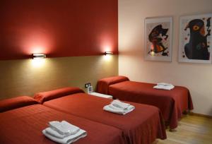 a hotel room with two beds with towels on them at Center Gran Via in Barcelona