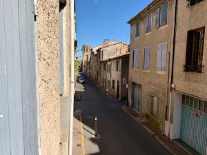 uma rua vazia num beco entre dois edifícios em Appartements Voltaire - Carcassonne Centre em Carcassonne