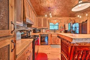 a large kitchen with wooden cabinets and a large island at Western Daze Broken Bow Cabin in Hochatown! in Stephens Gap