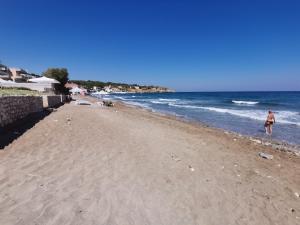 Un uomo che cammina su una spiaggia vicino all'oceano di Domus Aries a Rethymno