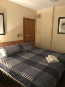 a bedroom with a blue bed with a white pillow at Shanahans B&B with Sports Bar in Birmingham