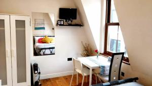 a small apartment with a table and a bedroom at White's Row Resident in London