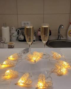 two glasses of wine on a kitchen counter with lights at Đurđevak lux in Banja Koviljača