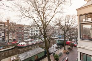 a view of a canal in a city with boats at ITC Hotel in Amsterdam