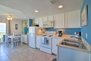 a kitchen with white cabinets and a sink and a table at Oceanfront Unit with Gulf View by Bayside Attractions in South Padre Island