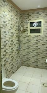 a bathroom with a toilet and a shower at Rose Tulip Served Apartments وردة الخزامى للشقق المخدومة in Riyadh