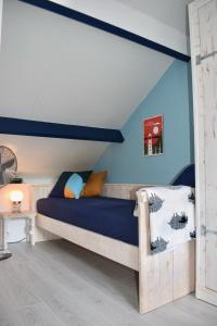 a bedroom with a wooden bed with blue walls at B&B Vloedlijn Texel in Den Burg