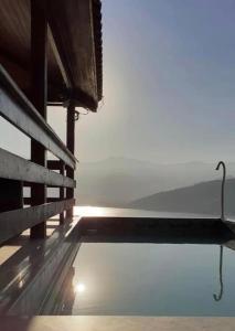 una piscina de agua junto a un edificio con el cielo en Chalé da Clarissinha en Mangaratiba