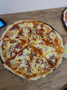 uma pizza sentada em cima de uma mesa de madeira em Hotel Don Chema em San Pedro La Laguna