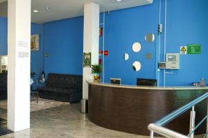 a lobby with a blue wall and a couch at Palace Hotel in Araguari