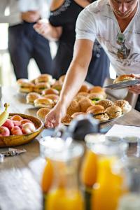 a man reaching for a plate of food on a table at Buitengewoon Overnachten in Terheijden