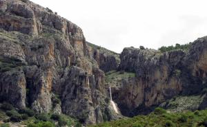 une montagne rocheuse avec une cascade sur son côté dans l'établissement Habitacion de la marquesa, à Alcoleja