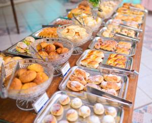 a table with many trays of pastries and other foods at Palace Hotel in Araguari