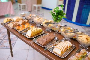 a table filled with different types of bread and pastries at Palace Hotel in Araguari