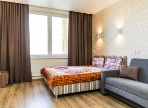 a bedroom with a bed and a couch and a window at Sokol-Hotel in Moscow