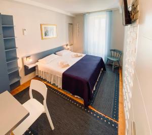 a bedroom with a bed and a table and a chair at Komiza Provita Guesthouse in Komiža