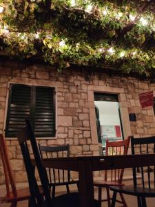 a table and chairs in front of a stone building at Beach House Gusla in Komiža