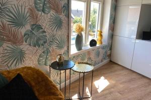 a room with a table and a wall with plants at Tiny House Experience Oud Beijerland in Oud-Beijerland