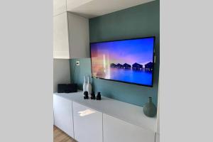 een woonkamer met een flatscreen-tv aan de muur bij Tiny House Experience Oud Beijerland in Oud-Beijerland