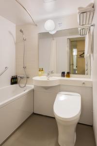 a white bathroom with a toilet and a sink at Via Inn Prime Nihonbashi Ningyocho in Tokyo