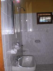 y baño con lavabo y ducha. en Hostel Rogupani en San Rafael