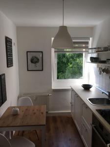 a kitchen with a wooden table and a window at FeWo Oberwiesenthal in Kurort Oberwiesenthal