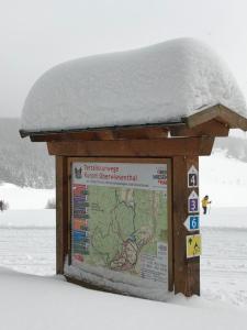 a sign in the snow with a snow covered roof at FeWo Oberwiesenthal in Kurort Oberwiesenthal