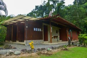 une petite maison rouge avec un toit dans l'établissement Pacuare River Lodge, à Bajo Tigre
