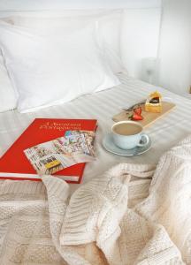 ein Bett mit einer Tasse Kaffee und einem Buch in der Unterkunft New! Nice FAMILY Apartment with 2 Bedroom, 2 Terrace in Costa da Caparica
